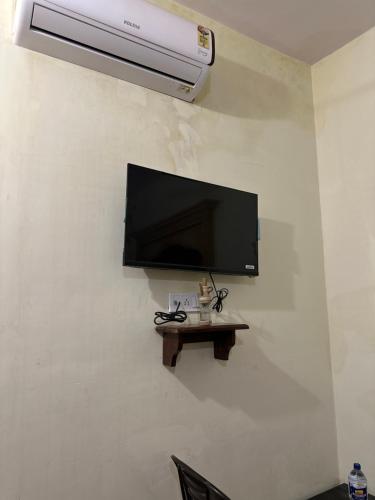 a flat screen tv hanging on a wall with a table at Relax Inn Jaisalmer in Jaisalmer
