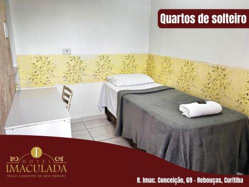 a room with a bed and a table with towels on it at Hotel imaculada in Curitiba