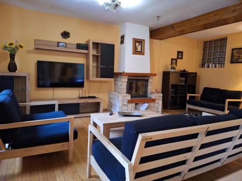 a living room with a couch and a television at Vila Plai Predeal in Văleni