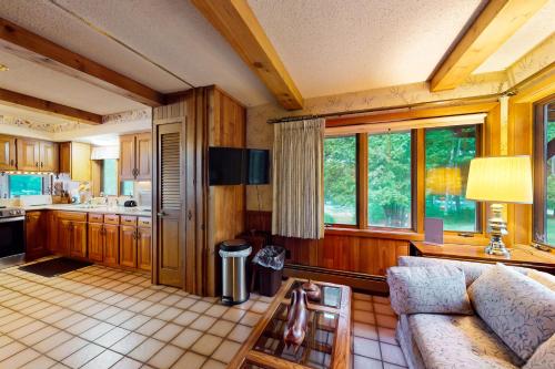 a living room with a couch and a kitchen at Lakefront Haven in Lake Tomahawk