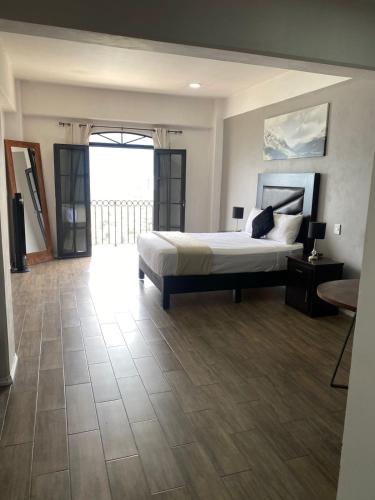 a large bedroom with a bed and a balcony at Hotel Santa María in Taxco de Alarcón