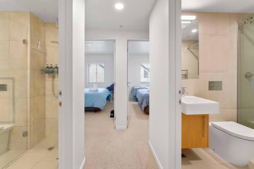 タウポにあるOn the Edge of Town Apartmentのバスルーム(洗面台、トイレ付)、ベッド1台が備わります。