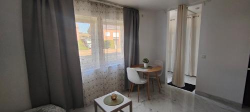 a room with a table and chairs and a window at Studio spacieux ,chaleureux et cosy in Heers