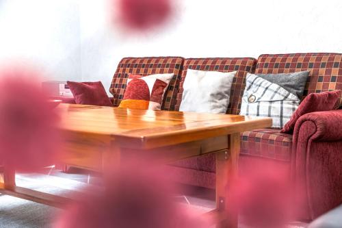 a couch with pillows on it with a wooden table at Ferienhaus Franziska in Münstermaifeld