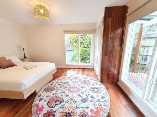 a bedroom with a bed and a rug and a window at Between the Yarra Valley, City, wineries. Pets in Mooroolbark