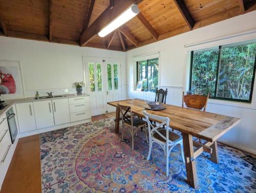 a large kitchen with a wooden table and chairs at Sandys Pottery Cottage- pet friendly, wineries, in Healesville