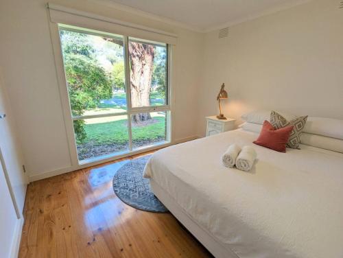 a bedroom with a bed and a large window at Sandys Retreat, wineries, sanctuary, pets, main st in Healesville