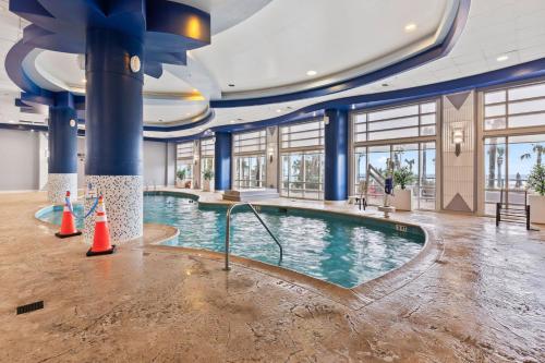 a swimming pool in a building with blue columns at -New Listing- Completely Remodeled and Newly Furnished 3BR Direct Ocean Front Condo in Seabreeze