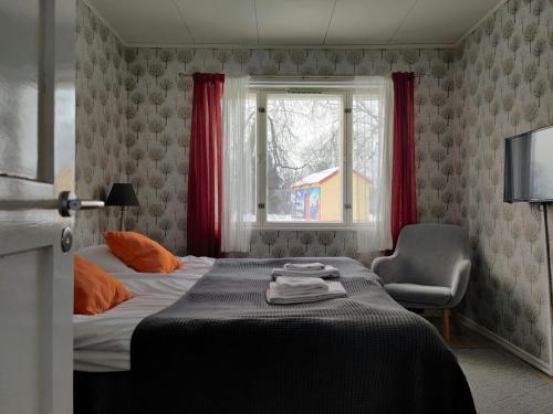 a bedroom with a bed and a chair and a window at Convenient Apartment for 4 in Kemi