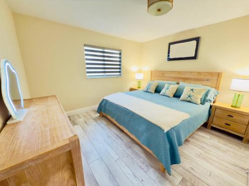 a bedroom with a blue bed and a window at Serenety Shores in West Palm Beach