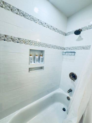 a white bathroom with a tub and a sink at Serenety Shores in West Palm Beach