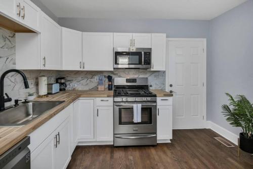 a kitchen with white cabinets and a stove top oven at The Orchard at Isabel-Near USC in Hyatts