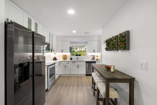 a kitchen with white cabinets and a wooden table at Stroll to Downtown Alpharetta AND Avalon Shops in Alpharetta