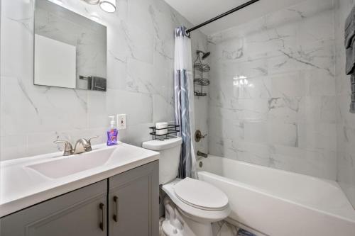 une salle de bain blanche avec un lavabo et des toilettes dans l'établissement Cozy Two Bedroom in Brooklyn, à Brooklyn