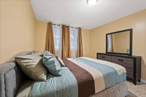 une chambre avec un lit avec une commode et un miroir dans l'établissement Cozy Two Bedroom in Brooklyn, à Brooklyn