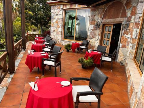 a row of tables with red table cloths on a patio at Villa Kristiano 21 in Sarandë