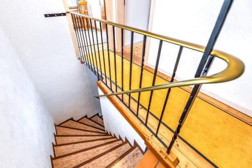 a staircase with a gold rail and a window at Ferienhaus Franziska in Münstermaifeld