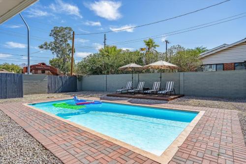 a swimming pool in a yard with two chairs at Tucson Oasis by Rather Be Properties in Tucson