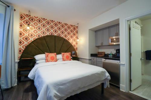 a bedroom with a large bed and a kitchen at Good Hotels Boston in Boston