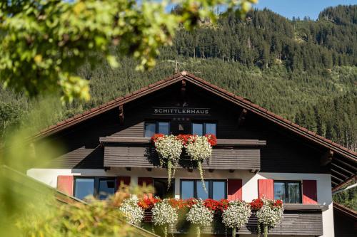a building with flower pots on the front of it at Schittlerhaus in Oberstdorf