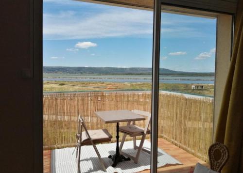a table and chairs on a balcony with a view at Studio plage avec parking in Frontignan