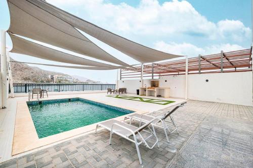 a swimming pool with a large canopy over it at The Pearl Villa - Swimming Pool with Sea and Mountain view - Al Dana Island Fujaira in Fujairah
