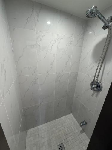 a bathroom with a shower with a white tiled floor at Spacious 5-Bedroom House in Thornhill in Vaughan