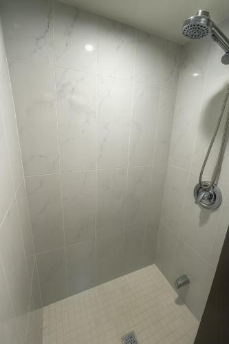 a shower in a bathroom with a white tile floor at Spacious 5-Bedroom House in Thornhill in Vaughan