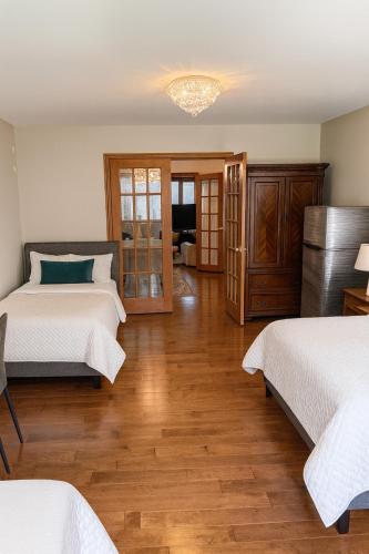 a bedroom with two beds and a wooden floor at Spacious 5-Bedroom House in Thornhill in Vaughan