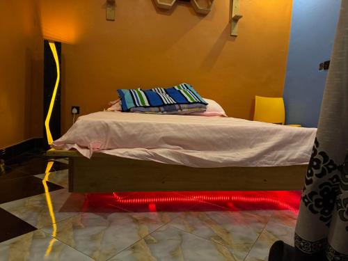 a bed with two pillows on it in a room at Vales Room in Mpigi