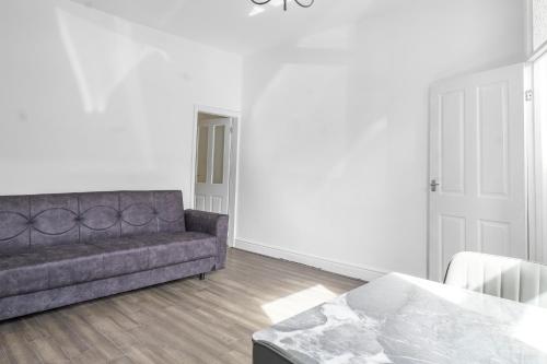 a living room with a couch and a table at Modern Bury Retreat - Free Parking, Easy Manchester Access in Tottington