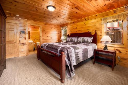 una camera da letto con un letto in una cabina di legno di Bear Tracks a Gatlinburg