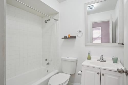 a white bathroom with a toilet and a sink at Charming Soulard Retreat with Historic Character near Baseball Stadium apts in Soulard