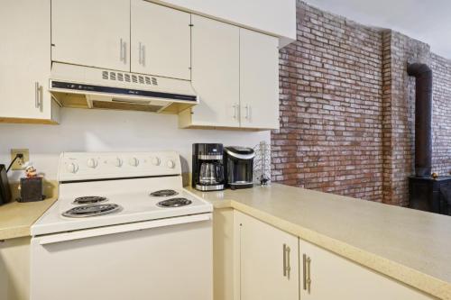 a kitchen with white cabinets and a white stove top oven at Charming Soulard Retreat with Historic Character near Baseball Stadium apts in Soulard