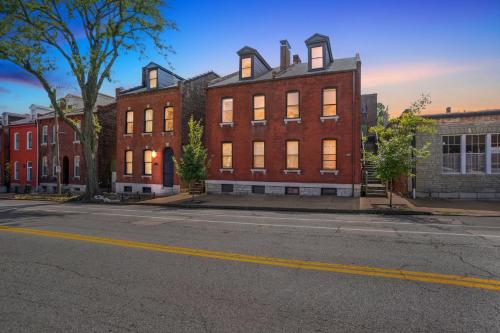 a large brick building on a city street at Charming Soulard Retreat with Historic Character near Baseball Stadium apts in Soulard