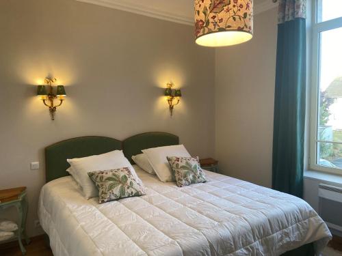 una camera da letto con un letto con due cuscini sopra di Séjour Royal au Coeur de Calais a Calais
