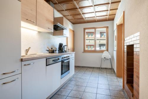 a kitchen with white appliances and a tile floor at Highalp Apartments in Tannheim