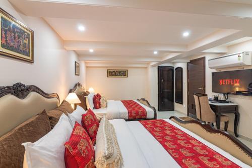 a hotel room with two beds and a desk at Palm Residences and Suites in Jaipur