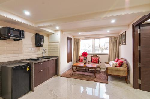 a kitchen and living room with a couch and a table at Palm Residences and Suites in Jaipur
