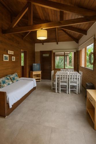 a bedroom with a bed and a dining room at KEIKI Complejo Cabañas in La Porteña