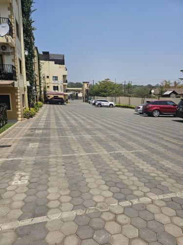 a cobblestone street with cars parked in a parking lot at Ahava Home in Lusaka