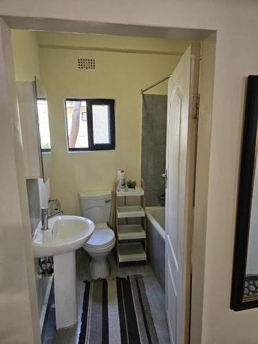 a bathroom with a sink and a toilet and a tub at Ahava Home in Lusaka