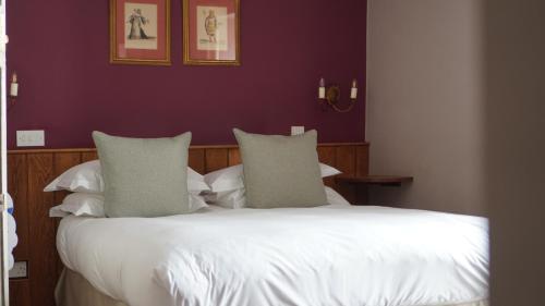 a bedroom with a bed with white sheets and pillows at Montigo Resorts, Somerset in Shepton Mallet