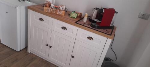 a kitchen counter with white cabinets and a red appliance at La Casetta in San Salvatore Monferrato