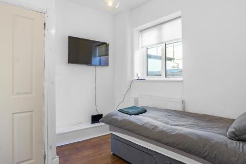 a bedroom with a bed and a flat screen tv at Modern Bury Retreat - Free Parking, Easy Manchester Access in Tottington