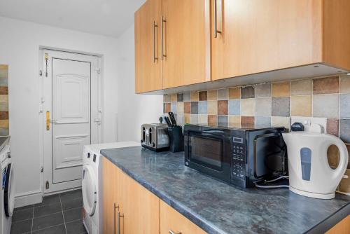 a kitchen with a counter top with a microwave at Modern Bury Retreat - Free Parking, Easy Manchester Access in Tottington