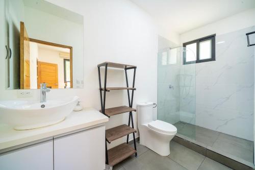 a bathroom with a sink and a toilet and a shower at CasaBlanca with Pool, 5 min from the Ocean in Cuajiniquil