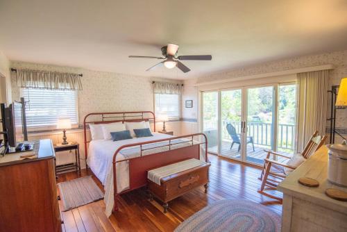 a bedroom with a bed with a ceiling fan at 1 Bedroom Cabin Overlooking New River-- Sleeps 4, Dogs OK, Fire Pit & More in Glendale Springs