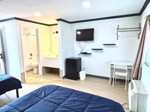 a bedroom with a bed and a desk and a tv at Jet Inn Motel-SeaTac, Tukwila in Tukwila