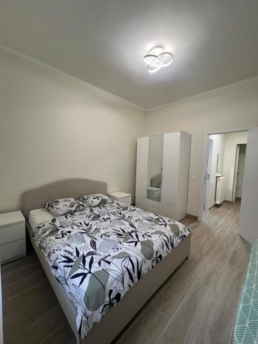a bedroom with a bed with a black and white comforter at Superbe appart près de la mer in Nice
